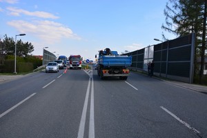 Zablokowana ul. Podkarpacka w Krośnie. Obok ciężarowego mercedesa, wóz bojowy straży pożarnej i wydzielona pachołkami drogowymi strefa działań ratwniczych