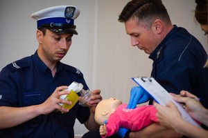 Policyjni ratownicy podczas inscenizowanej interwencji udzielają pomocy niemowlęciu