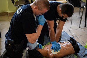 Policyjni ratownicy podczas inscenizowanej interwencji prowadzą resuscytację krążeniowo-oddechową na fantomie