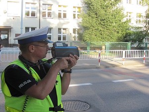 Na zdjęciu policjant dokonujący pomiaru prędkości.