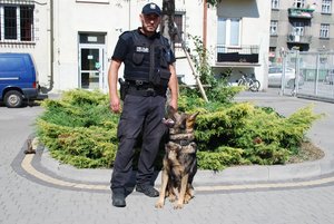 Przewodnik psa służbowego mł. asp. Bartłomiej Ciupak i pies KRAK na dziedzińcu rzeszowskiej komendy.