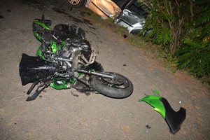 Uszkodzony motocykl leżący na jezdni.