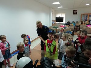 Kolorowa fotografia. Świetlica komendy w Leżajsku. Dzieci oglądają elementy umundurowania i wyposażenia policyjnego.