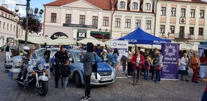 Na Rynku w Rzeszowie podczas pikniku pn &#039;Dzień Serca w Rzeszowie&quot; policjanci prezentują sprzęt służbowy: motocykl Harley-Davidson, radiowozy oraz stoisko profilaktyczne.
