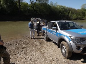 Policjanci wodują łódź do rzeki