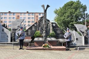 Pomnik Pamięci Narodowej w Jarosławiu. Obok niego dwaj umundurowani policjanci.