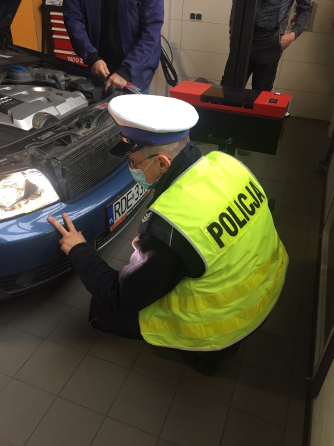 Policjant podczas kontroli oświetlenia pojazdu