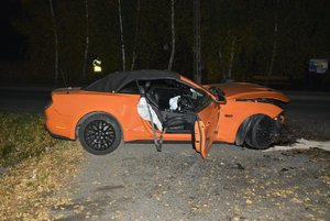 Zdjęcie wykonane w porze nocnej -  przedstawia miejsce zdarzenia drogowego w miejscowości Buszkowiczki . Na zdjęciu widoczny jest pojazd marki ford mustang koloru pomarańczowego.