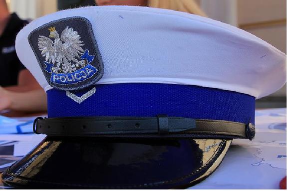 Zdjęcie przedstawia czapkę policjanta ruchu drogowego , która leży na podszybiu samochodu