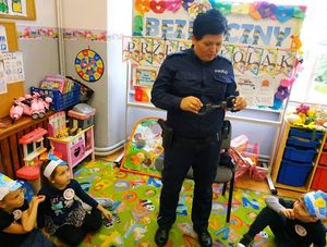 Policjantka pokazuje dzieciom jak wyglądają kajdanki