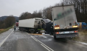 Naczepy zniszczonych pojazdów w Lipowicy i czarna kabina jednej z ciężarówek. W tle ratownicy pracujący na miejscu zdarzenia