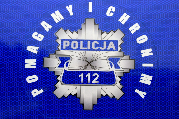 Policyjna gwiazda na granatowym tle z napisem POLICJA numerem 112 i hasłem POMAGAMY I CHRONIMY
