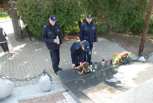 Policjantka składająca wiązankę pod pomnikiem Katyńskim w Strzyżowie