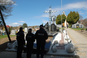 policjanci przed pomnikiem katyńskim