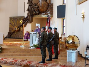 Wojskowy poczet sztandarowy podczas wygłaszanej przez biskupa homilii. W tle koncelebrujący mszę świętą kapłani