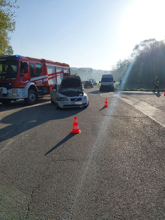 Skrzyżowanie drogi w miejscowości Brzeziny. Na pierwszym planie widoczny uszkodzony w zdarzeniu drogowym pojazd marki Volvo. Po jego lewej stronie stoi wóz strażacki a w głębi zdjęcia widoczny dostawczak, drugi pojazd biorący udział w  zdarzeniu.
