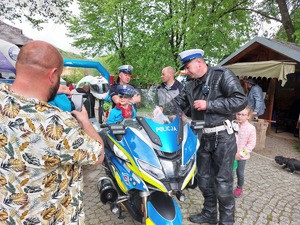 Na zdjęciu osoby uczestniczące w &quot;Dniach Otwartych Funduszy Europejskich&quot;oglądające policyjny motocykl oraz radiowóz.