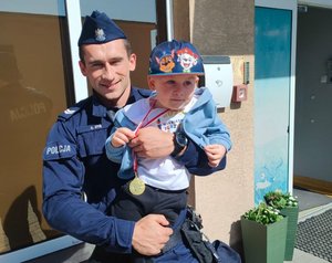 Policjant z dzieckiem na rękach