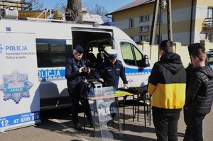 Policjanci przy swoim stoisku rozmawiający z dziećmi