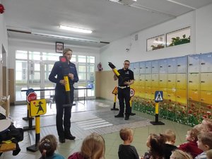 Policjanci pokazujący dzieciom poszczególne kolory sygnalizacji świetlnej