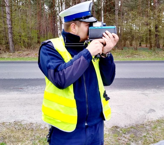 policjant ruchu drogowego prowadzi pomiar prędkości pojazdów