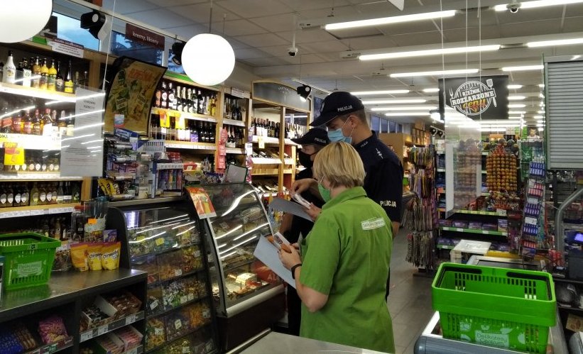 Funkcjonariusze z Wydziału Prewencji Komendy Wojewódzkiej Policji w Rzeszowie prowadzą kontrolę w sklepie, w ramach działań profilaktycznych „Alkohol - ograniczona dostępność”. Na zdjęciu policjanci w towarzystwie ekspedientki.