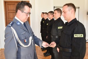 I Zastępca Komendanta Wojewódzkiego Policji w Rzeszowie wręcza legitymacje nowo przyjętemu policjantowi.