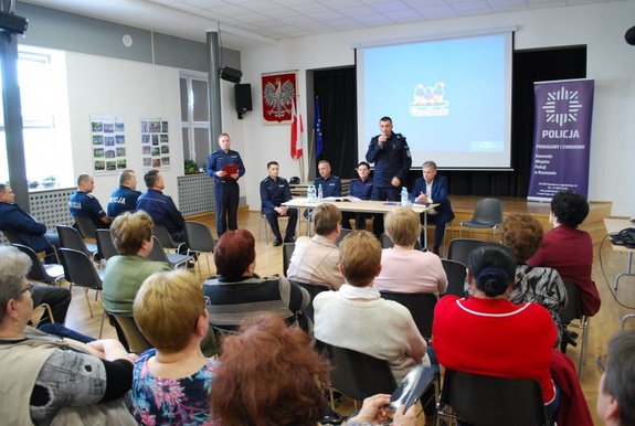 Zastępca Komendanta Miejskiego Policji w Rzeszowie otwiera debatę społeczną w sali Gminnego Ośrodka Kultury w Lubeni