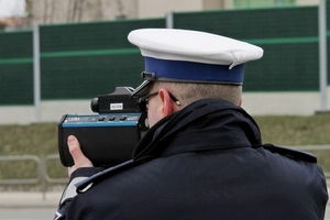 Policjant dokonujący pomiaru prędkości laserowym miernikiem prędkości.