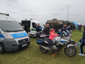 Dzieci siedzące na policyjnych motocyklach podczas pikniku balonowego.