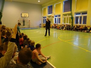Spotkanie policjanta z uczniami w sali gimnastycznej Zespołu Szkół w Zręcinie.