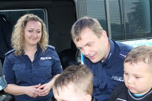 Policjanci na pikniku . obok stoją dzieci