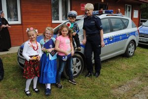Dzieci i policjantka obok radiowozu