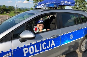 Chłopiec siedzący w radiowozie policyjnym.