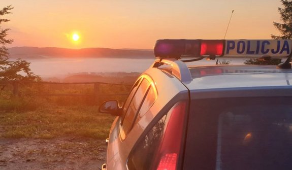 Policyjny radiowóz na tle wschodzącego słońca