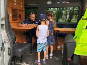 Policjant rozmawia z dziećmi.