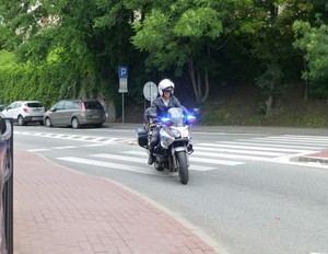 Policjant na motocyklu, zabezpieczający przemarsz.