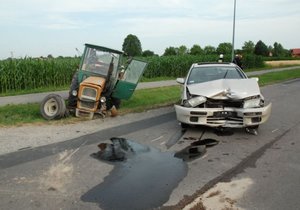 Na zdjęciu po lewej stronie w rowie widać uszkodzony traktor ursus. Na środku jezdni znajduje się samochód mazda. Pojazd ten ma uszkodzoną przednią cześć.