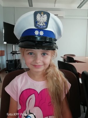 Dziewczynka w czapce funkcjonariusza z ruchu drogowego