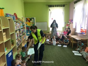 Policjantka rozdaje dzieci malowanki