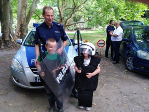 Przeworskie Dni Cleba- policjant wraz z dziecmi na tle radiowozu