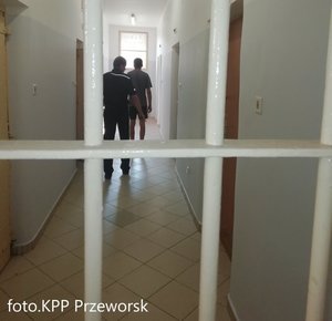 Funkcjonariusz oraz osoba zatrzymana w pomieszczeniu dla osób zatrzymanych