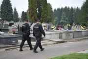 Policjanci patrolujący teren cmentarza.