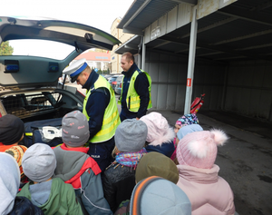 Przedszkolaki oglądają wyposażenie radiowozu policjantów ruchu drogowego