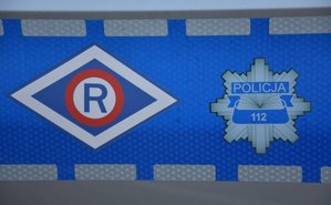 Logo ruchu drogowego i gwiazda policyjna na tle odblasku.