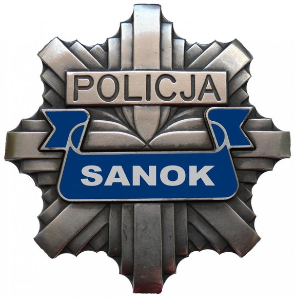 Policyjna gwiazda z napisem Policja w górnej części oraz napisem Sanoku w dolnej części.