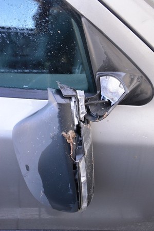 uszkodzone lusterko w zdewastowanym samochodzie