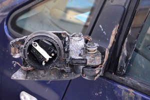 uszkodzone lusterko w zdewastowanym samochodzie