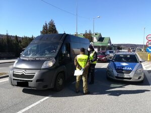 policjant i strażnik graniczny kontrolują kierowcę busa na przejściu w Barwinku