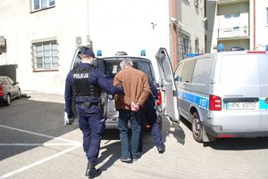 Na zdjęciu policjanci doprowadzający podejrzanego do prokuratury
